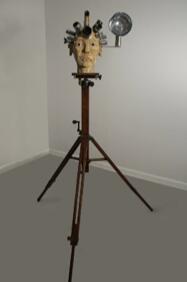 Carlos Estevez. Camera-man, 2006. Wood, photographic lenses, ready-made glass eyes and metal. Height 64 inches.