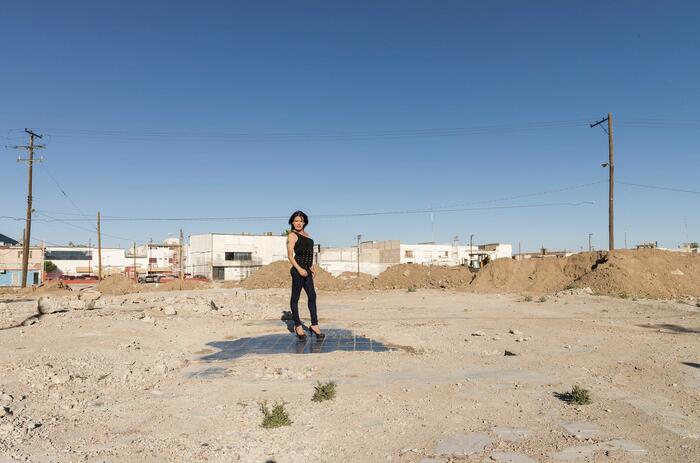 Trabajadora sexual transgénero de pie sobre la pista de baile de un club demolido en Ciudad Juárez, México C print en papel de algodón. Ph: Teresa Margolles.