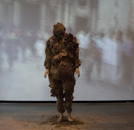 Tania Bruguera’s original performance of  Displacement, 1998-99, Cuban earth, glue, wood, nails and fabric; in Havana.; Performer reenacting Displacement at the Neuberger Museum of Art, Purchase, N.Y. Photo Jim Frank.; 
